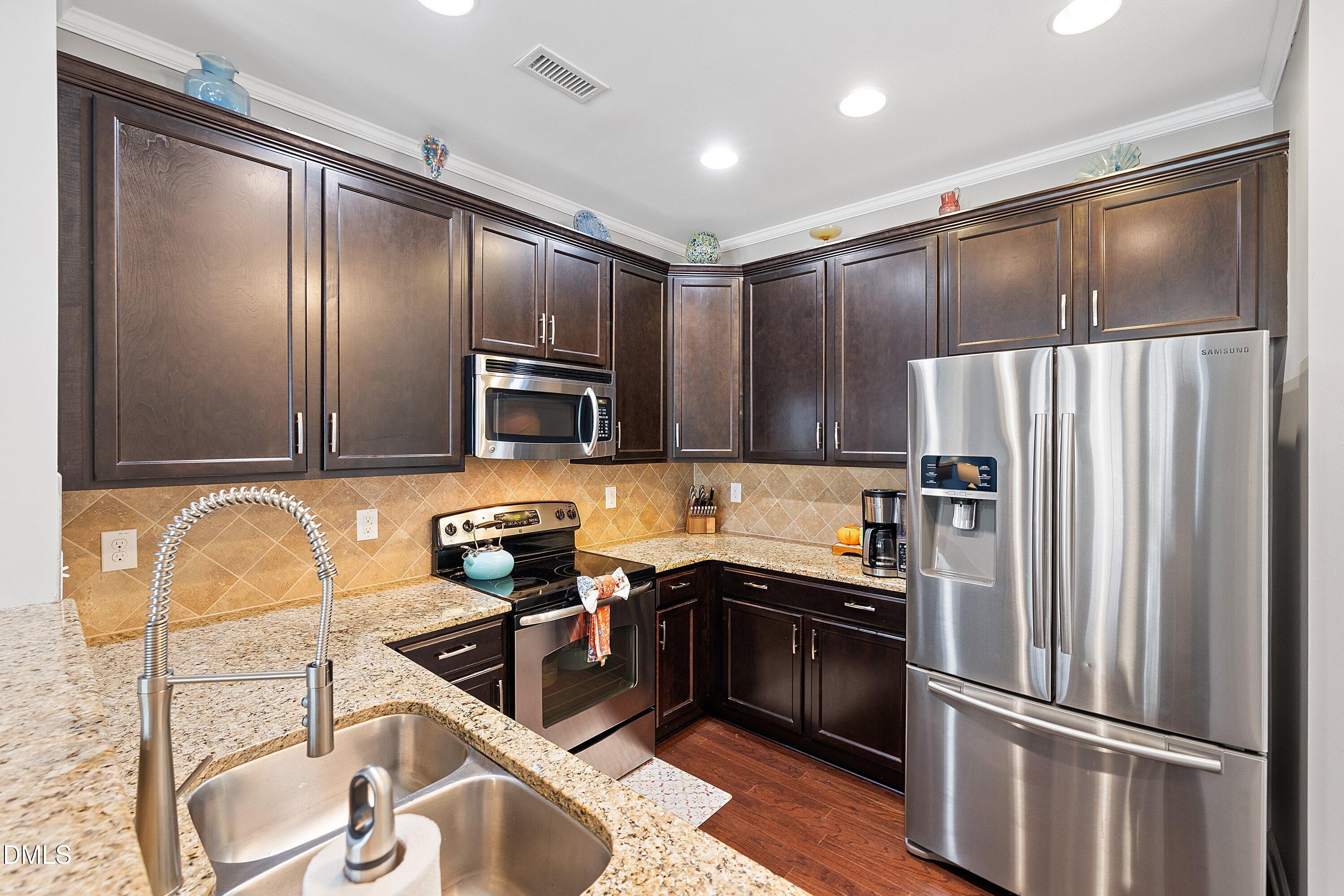 1093 Renewal Place Raleigh, NC 27603 - Photo 10 of 45 a kitchen with stainless steel appliances granite countertop a refrigerator stove and sink