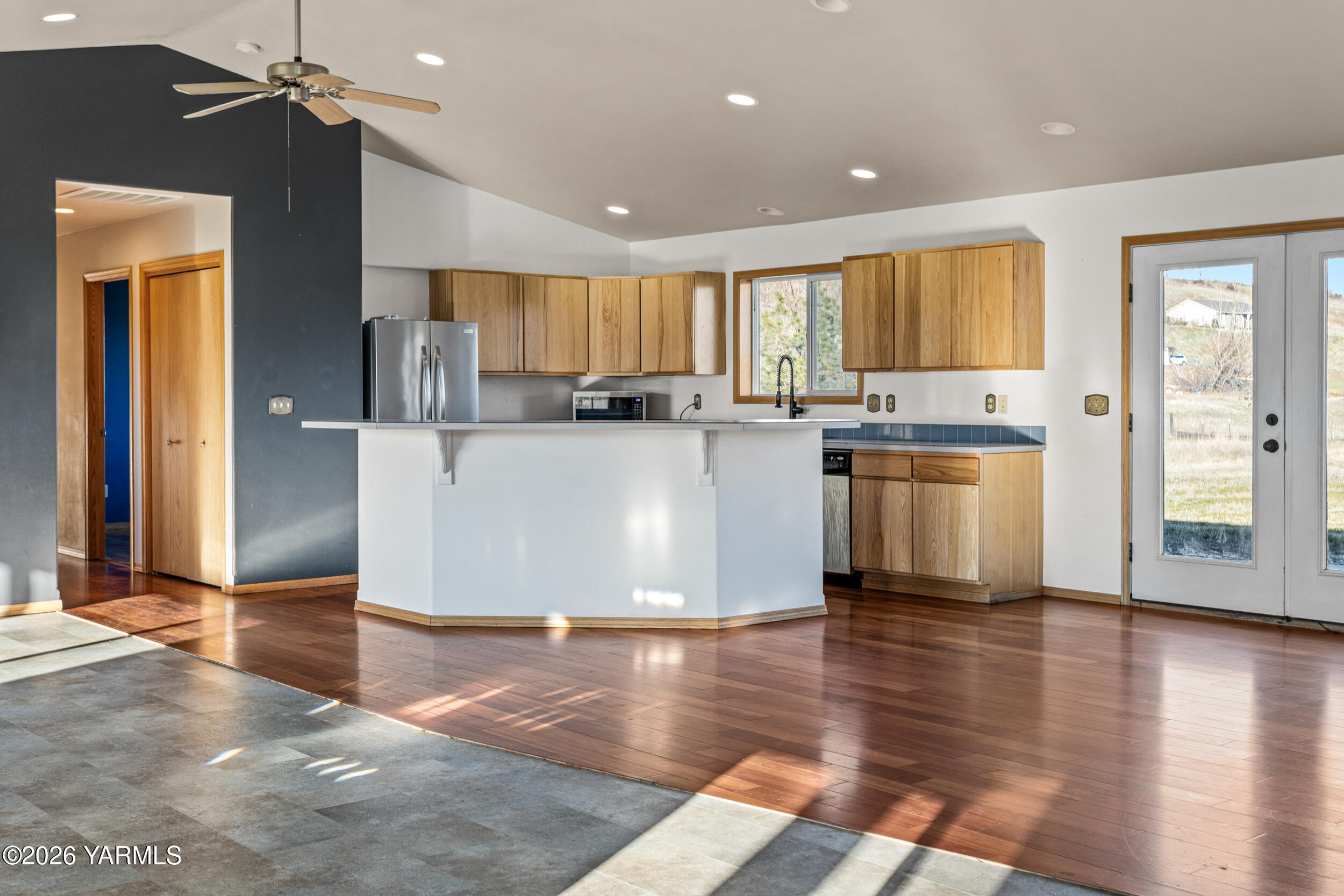 14929 Cottonwood Canyon Road Yakima, WA 98908 - Photo 12 of 55 a kitchen with stainless steel appliances granite countertop a refrigerator a sink dishwasher a stove and a dining table with wooden floor
