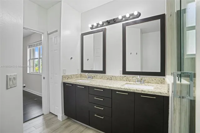 a bathroom with a granite countertop sink and a mirror