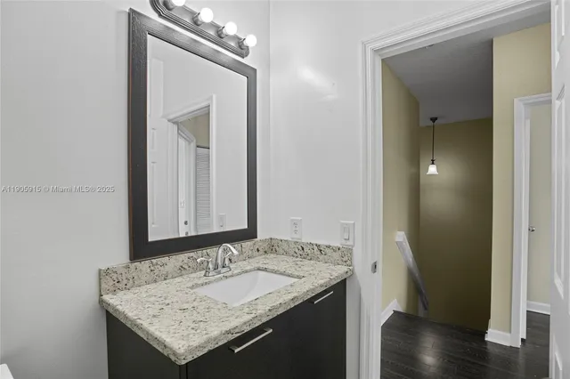 a bathroom with a granite countertop sink and a mirror