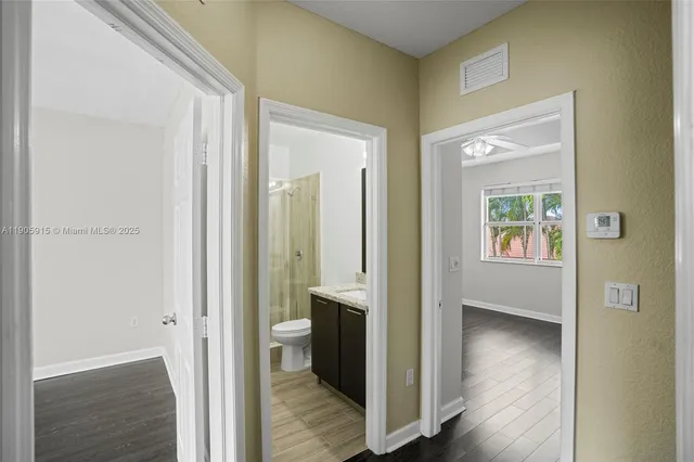 a view of a hallway with wooden floor and closet area