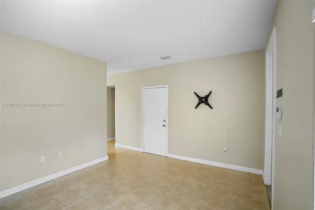 an empty room and chandelier fan