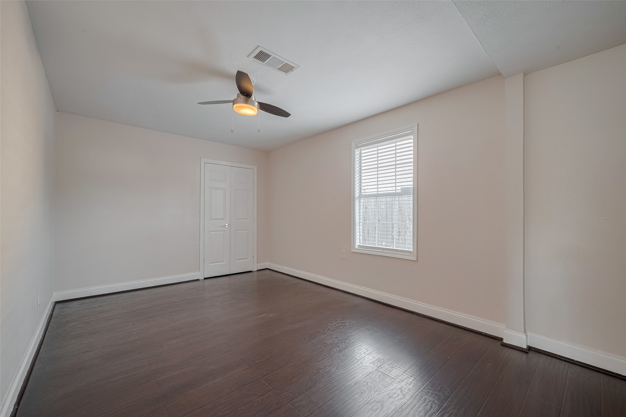 3930 Daphne Street Houston, TX 77021 - Photo 28 of 44 Filled with natural light, this well-proportioned bedroom combines comfort and function with its ceiling fan, cohesive palette, and a built-in closet that keeps essentials close and the space feeling open.