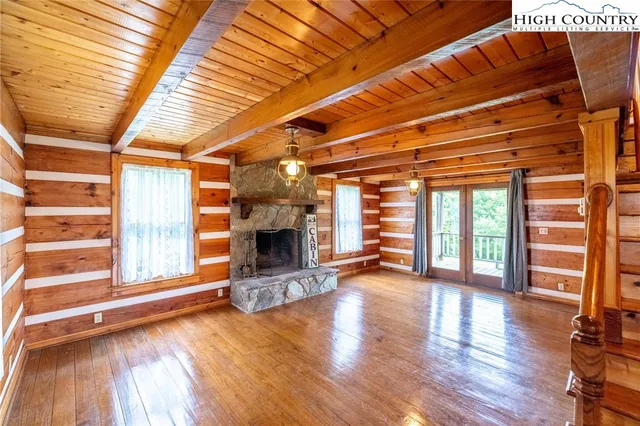 a view of a livingroom with wooden floor and a fireplace