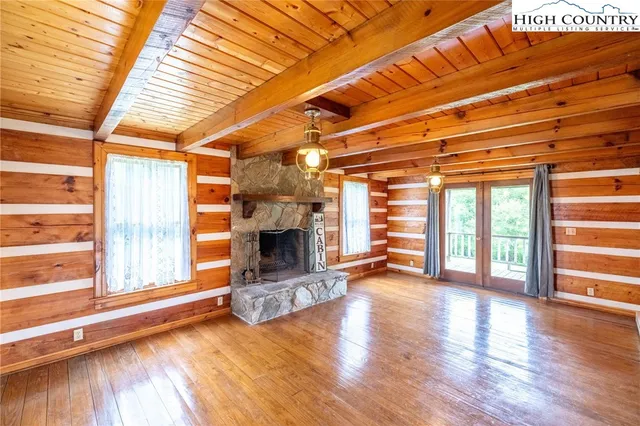 a view of empty room with wooden floor and fireplace