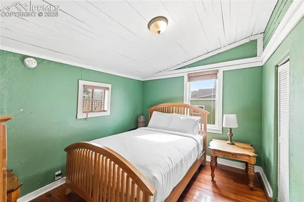 a bedroom with a bed and wooden floor