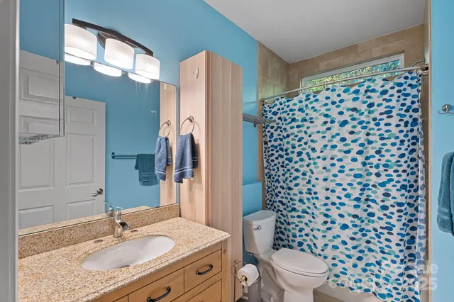 a bathroom with a granite countertop sink toilet and shower
