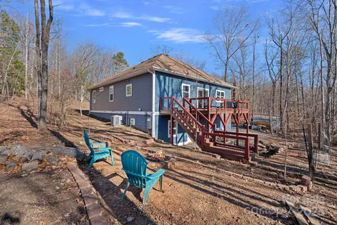 a view of a house with wooden deck next to a yard