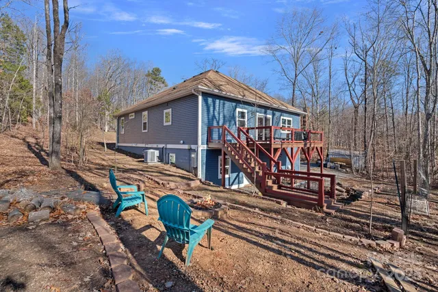 a view of a house with wooden deck next to a yard