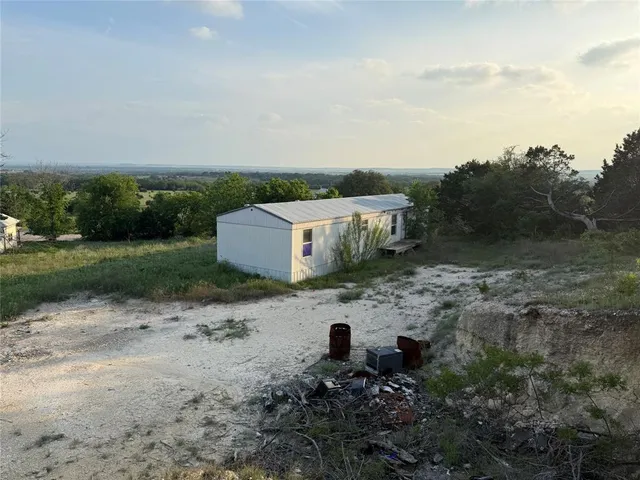 a view of a dry yard with wooden fence
