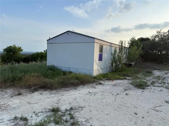 a view of a dry yard with wooden fence