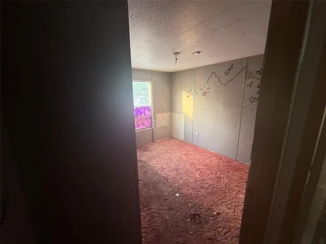 a view of empty room with windows and refrigerator