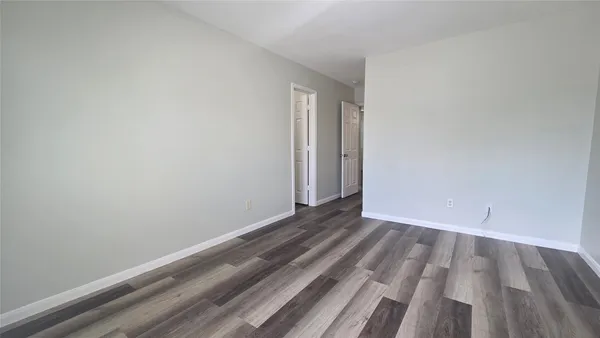 a kitchen with stainless steel appliances granite countertop a stove top oven a sink dishwasher and a refrigerator with wooden floor