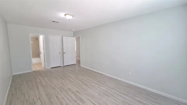 an empty room with wooden floor and window