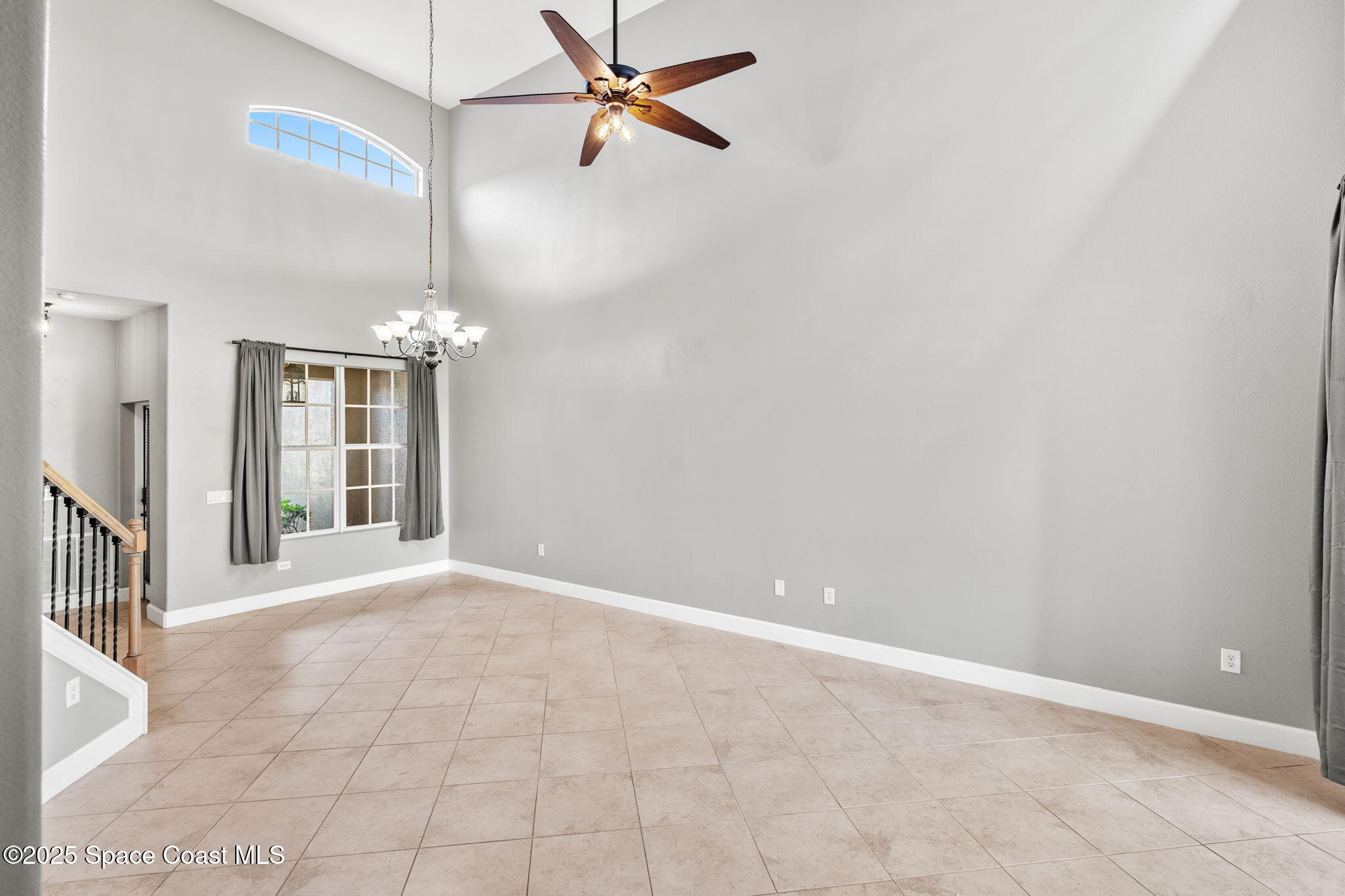3126 Arden Circle Melbourne, FL 32934 - Photo 13 of 33 an empty room with chandelier fan and windows