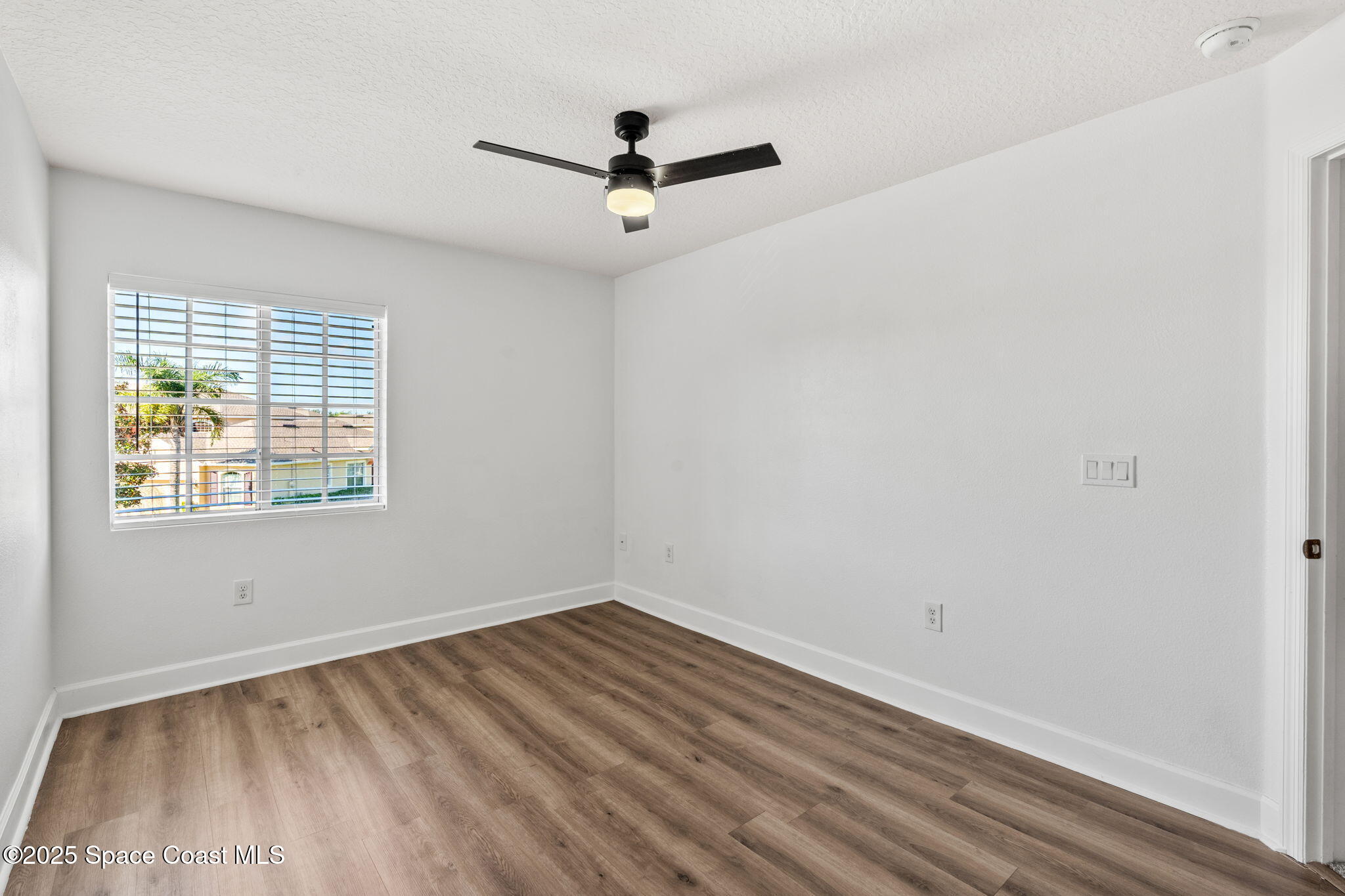 3126 Arden Circle Melbourne, FL 32934 - Photo 19 of 33 an empty room with a window and ceiling fan