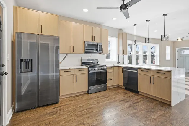 a kitchen with white cabinets stainless steel appliances and kitchen island