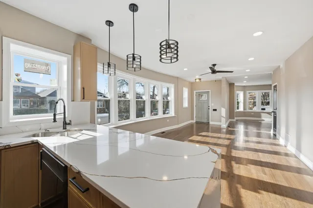 a kitchen with a sink a counter top space and living room view