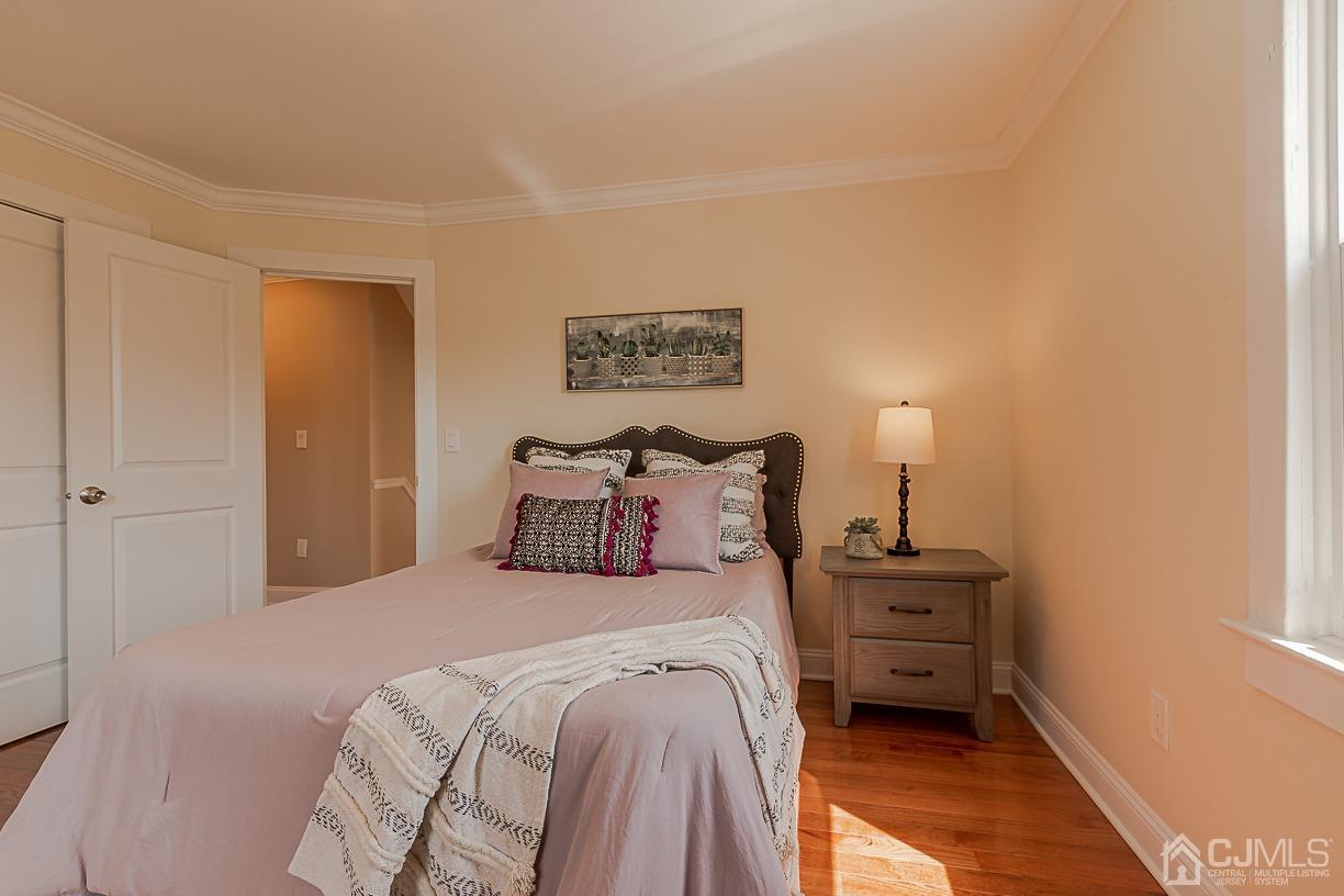 150 New Market Road Dunellen, NJ 08812 - Photo 17 of 22 a bedroom with a bed and a lamp on dresser