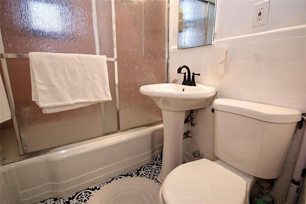 7259 Shore Road, Unit 5A Brooklyn, NY 11209 - Photo 12 of 18 a white toilet sitting next to a bathroom sink