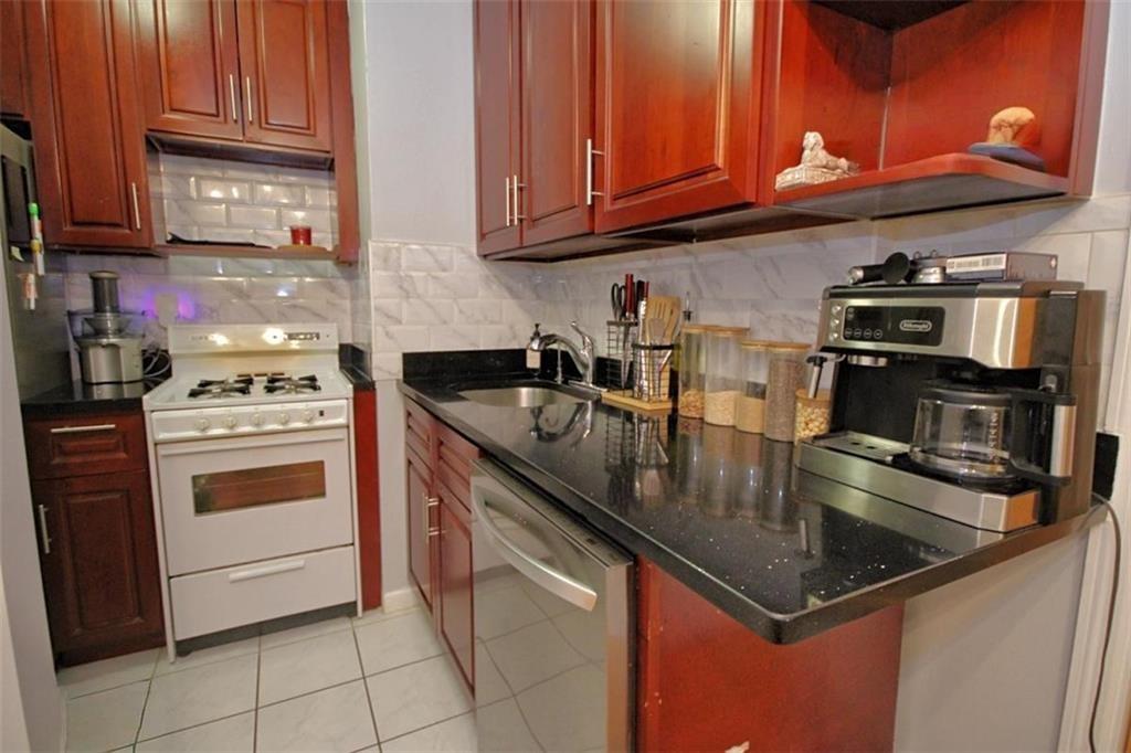 7259 Shore Road, Unit 5A Brooklyn, NY 11209 - Photo 10 of 18 a kitchen with stainless steel appliances granite countertop a sink stove and microwave