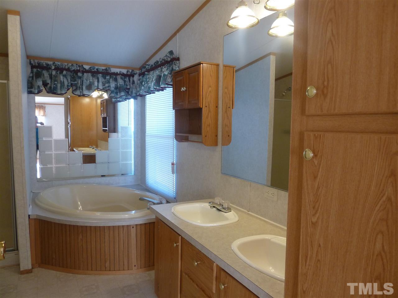 162 Isaac Trail Roxboro, NC 27574 - Photo 16 of 20 a bathroom with a tub sink and mirror