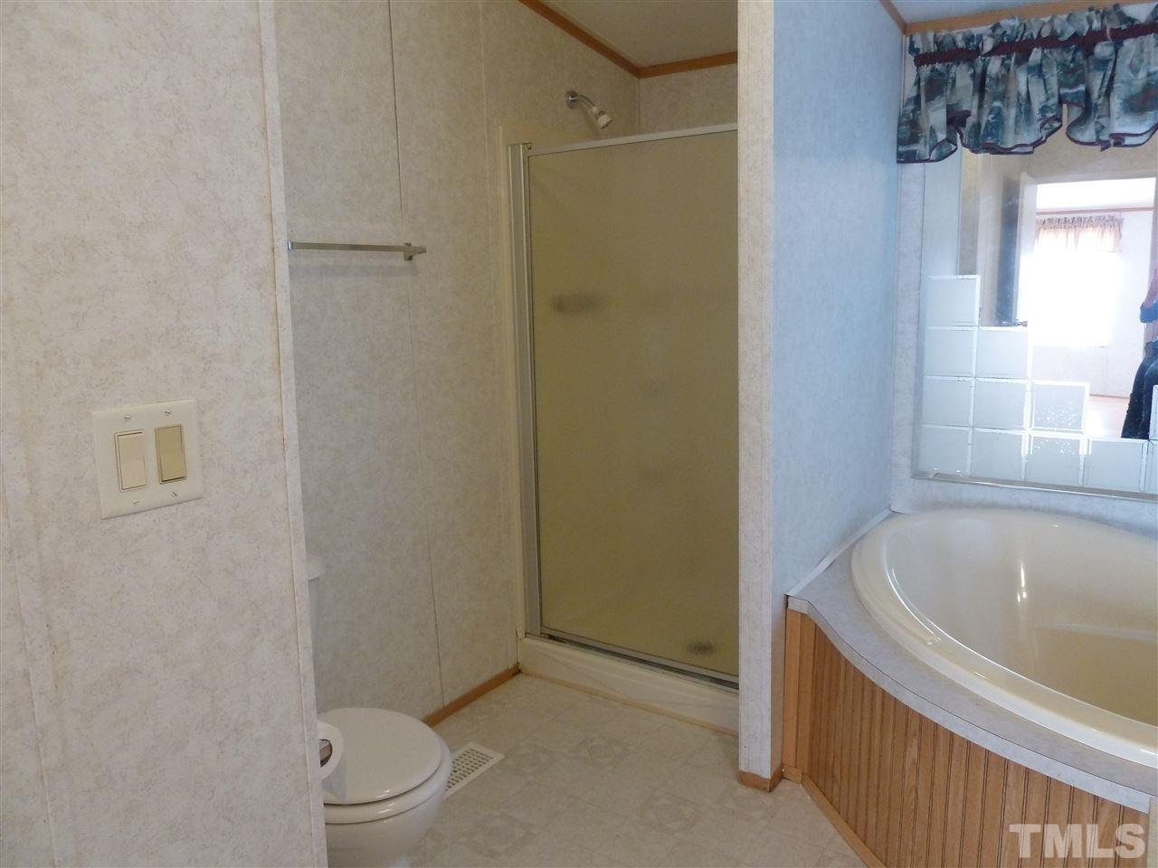 162 Isaac Trail Roxboro, NC 27574 - Photo 17 of 20 a bathroom with a bathtub a toilet and a shower