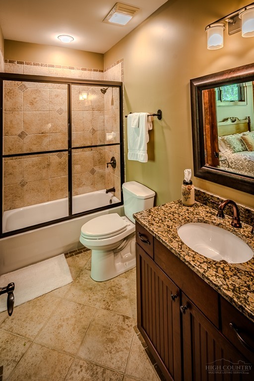 485 Woodlake Loop Road Elk Park, NC 28622 - Photo 19 of 44 a bathroom with a granite countertop sink mirror vanity and toilet