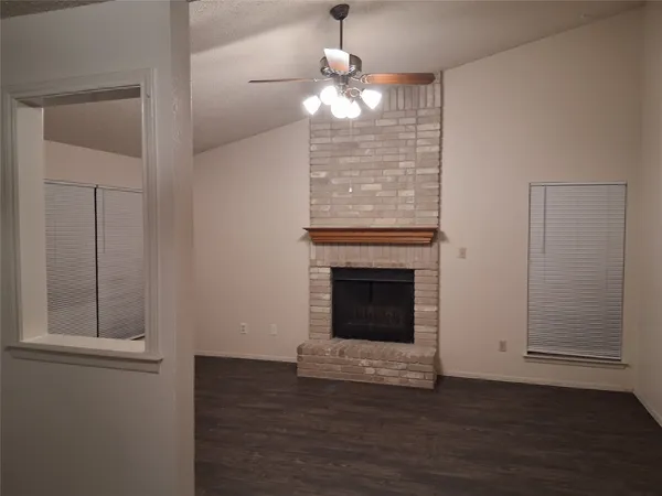 a view of a livingroom with a fireplace wooden floor and window
