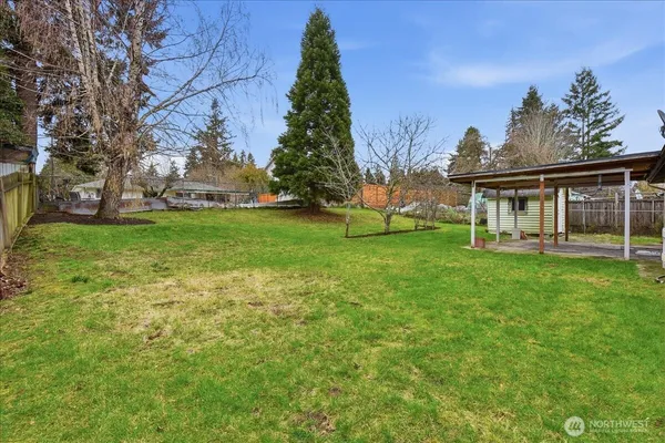 a view of a house with a big yard and large trees
