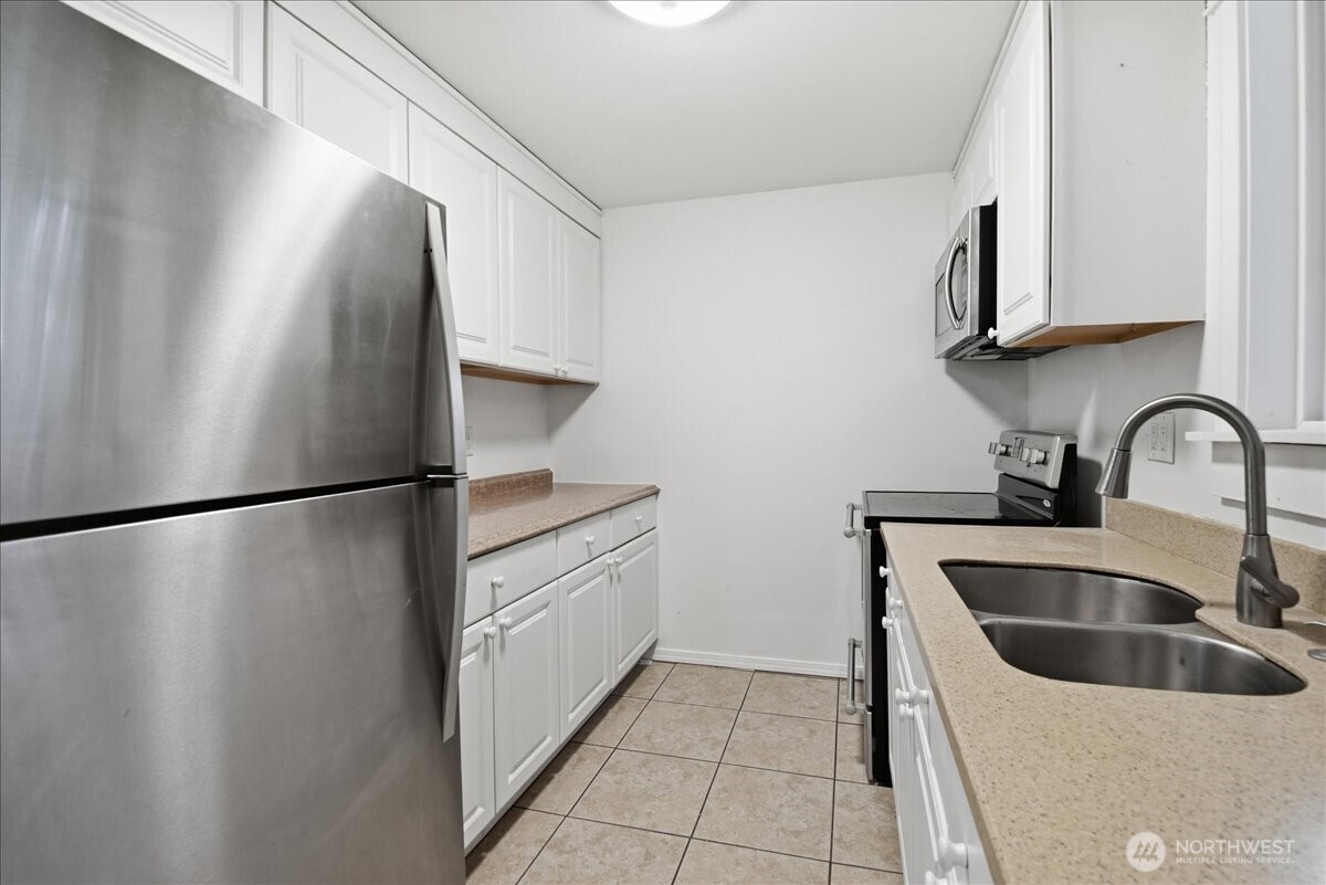 4404 Southeast 3rd Place Renton, WA 98059 - Photo 9 of 27 a kitchen with stainless steel appliances a refrigerator and a sink