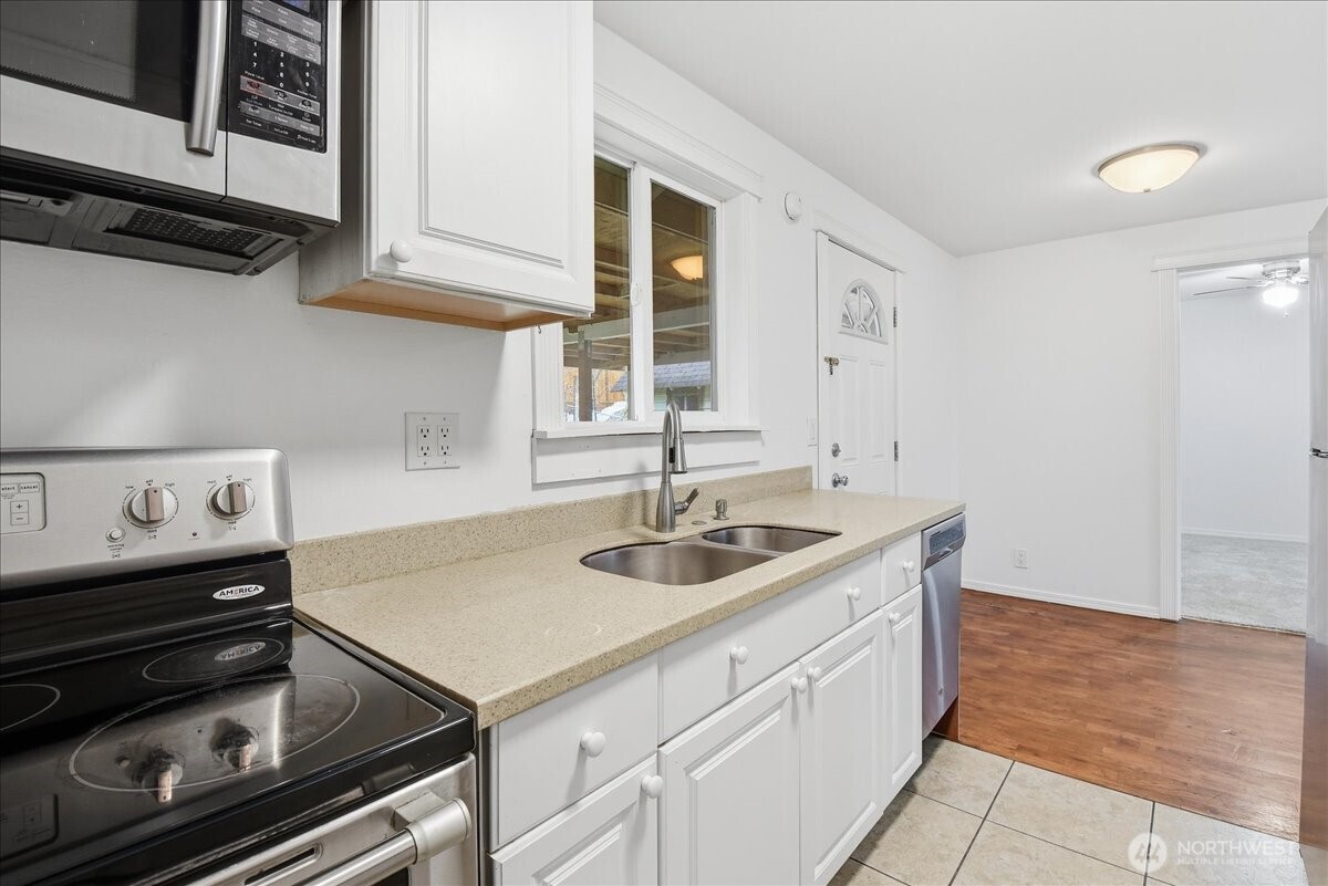 4404 Southeast 3rd Place Renton, WA 98059 - Photo 10 of 27 a kitchen with a sink stove and cabinets