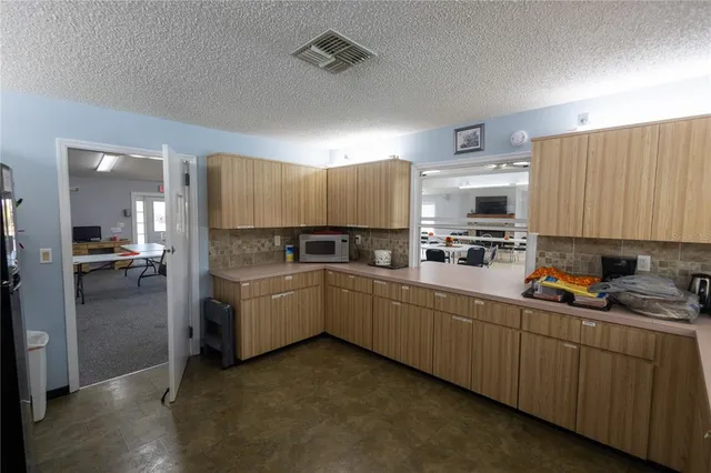 a kitchen with cabinets a sink and white appliances