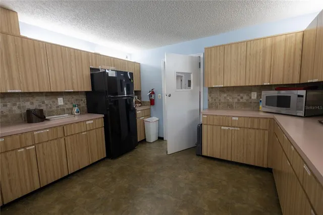 a kitchen with a refrigerator sink and cabinets