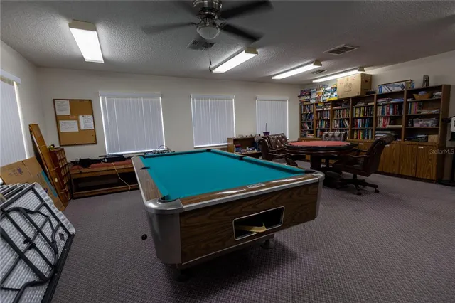 a room with furniture pool table and a window
