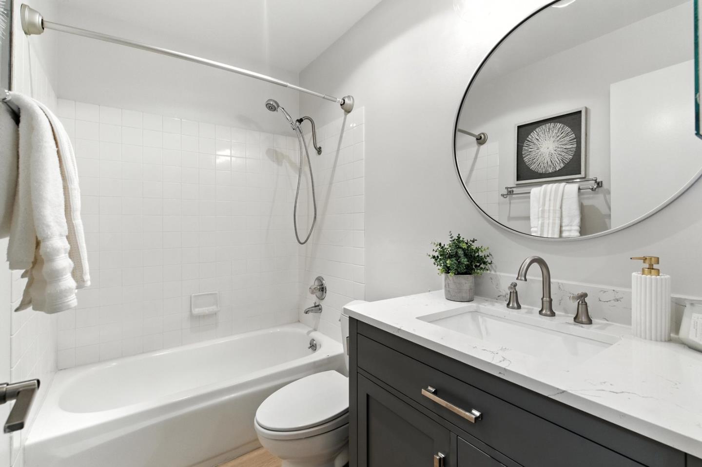 905 West Middlefield Road, Unit 974 Mountain View, CA 94043 - Photo 15 of 20 a bathroom with a granite countertop sink a mirror a bathtub and shower