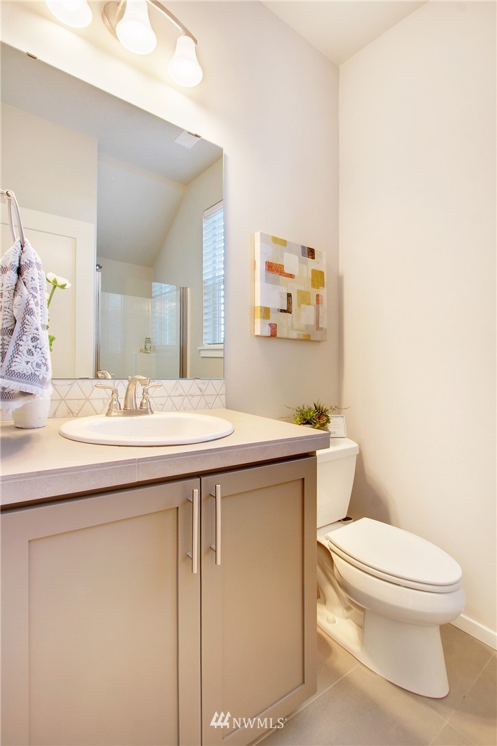 18631 Meridian Place West, Unit CC 10 Bothell, WA 98012 - Photo 4 of 27 a bathroom with a granite countertop toilet sink and mirror