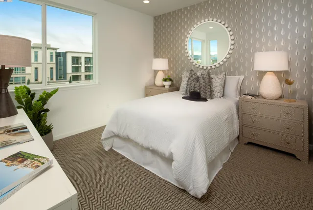 a bedroom with a bed potted plant with the dresser