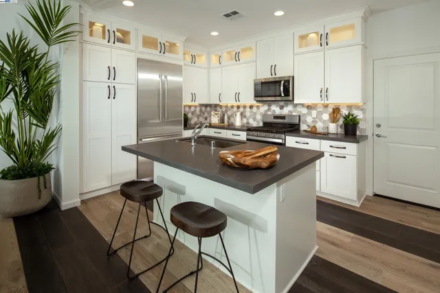 a kitchen with a refrigerator and a potted plant