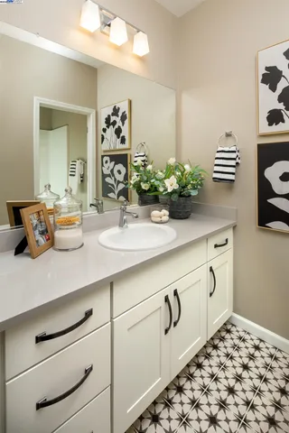a kitchen with white cabinets and sink