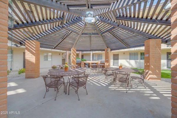 a view of a patio with table and chairs and floor to ceiling window wooden floor