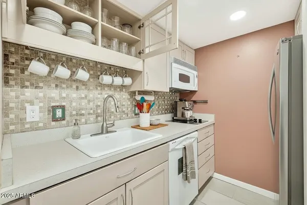 a kitchen with stainless steel appliances a sink and a refrigerator