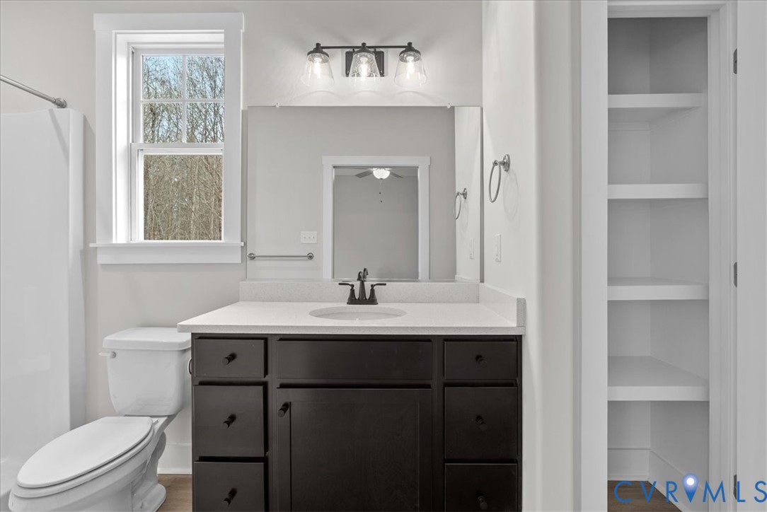 447 Raleigh Avenue South Hill, VA 23970 - Photo 20 of 31 a bathroom with a toilet a sink a mirror a window and vanity