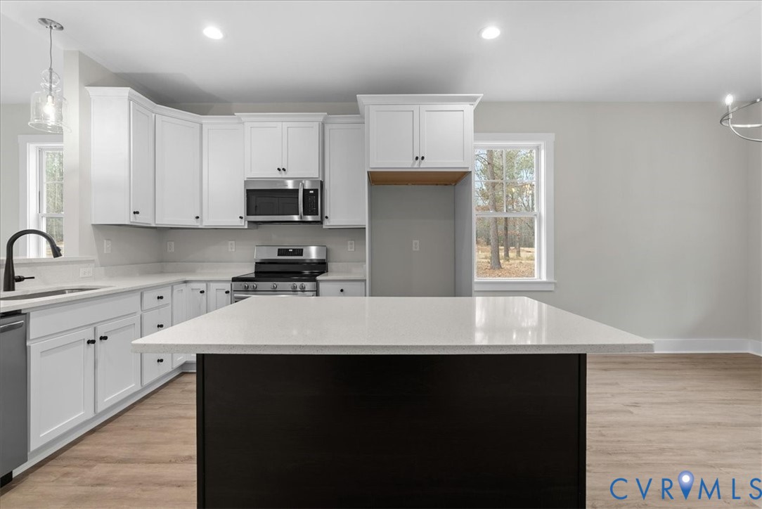 447 Raleigh Avenue South Hill, VA 23970 - Photo 23 of 31 a kitchen with kitchen island white cabinets sink and window