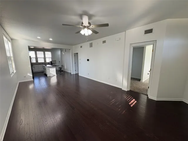 a view of empty room with wooden floor and window