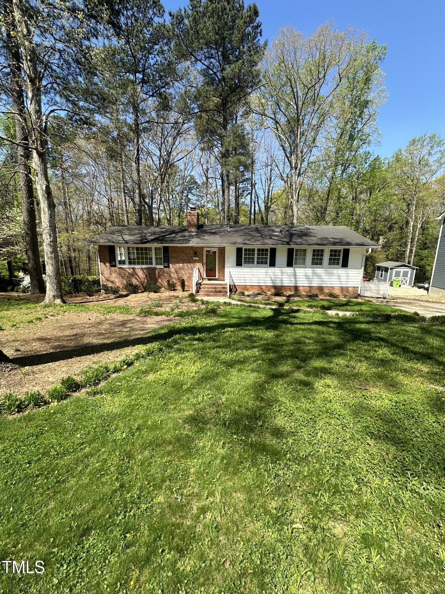 a front view of a house with swimming pool and trees