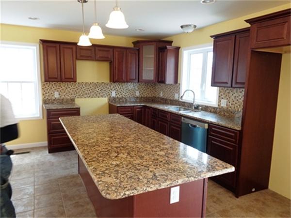 212 Mazarin Street Springfield, MA 01151 - Photo 3 of 22 a kitchen with kitchen island granite countertop wooden cabinets a sink and a stove