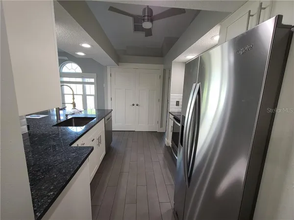 a kitchen with granite countertop a sink and steel appliances