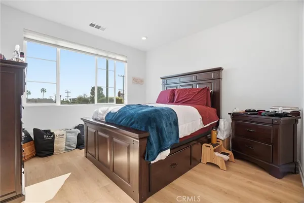 a bedroom with a bed and a dresser next to a window
