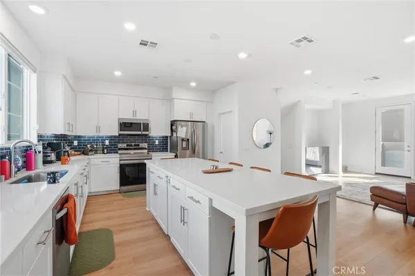 a kitchen with white cabinets stove and refrigerator